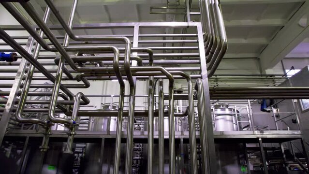 Gas transferring system with stainless pipes in chemicals manufacturing workshop. Shiny metal pipelines and cisterns at modern plant