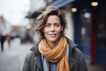 Portrait of happy middle-aged woman with scarf in the city