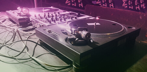 DJ mixer in a club in purple light in close-up