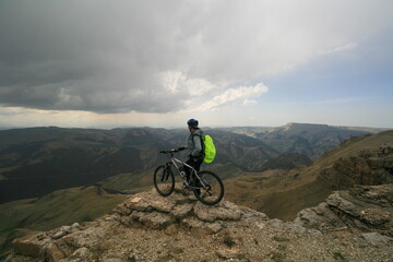 Fototapeta na wymiar A cyclist rides in the Caucasus mountains, the Bermamyt plateau, Russia.