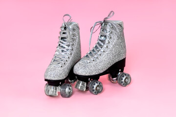 Close up photo of woman's body part. Legs wearing glamour silver glitter roller skates with...