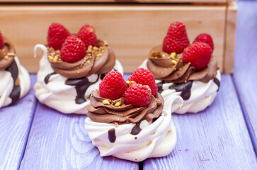 Mini cakes with whipped cream, chocolate, meringue and fresh raspberries. Confectionery poster for cafe or restaurant