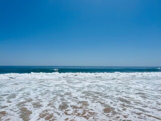 Beautiful ocean coast, waved ocean, surfing, clear blue sky