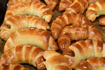 Delicious, soft bagels with apple filling rest on a baking tray.