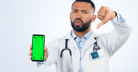 Phone, green screen and portrait of doctor with thumbs down, review or fake news in white background. Studio, healthcare or sign for negative, feedback and dislike mobile app for telehealth services
