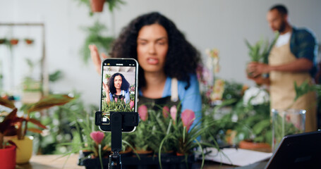 Smiling female social media blogger designer florist shooting new video on smartphone, talking...