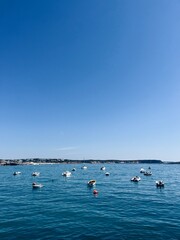 Fototapeta na wymiar Small fishing boats at the blue sea, blue clear sky