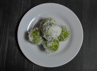 Klepon, traditional food or snack from Indonesia, made from glutinous rice flour and filled with brown sugar covered with grated coconut. Green klepon is made from pandan leaf juice.