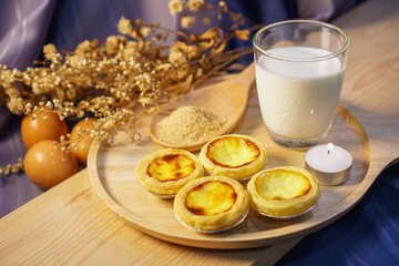 Egg tart with a glass of milk on a wooden table