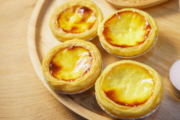 Egg tart with a glass of milk on a wooden table