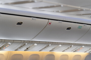 Carry-on luggage in overhead storage compartment on commercial airplane. Travel concept.