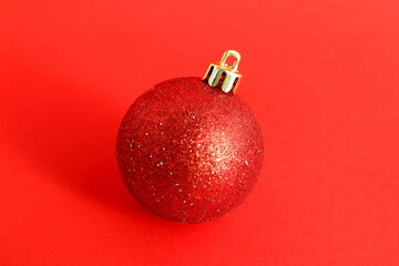 There is one Christmas tree toy on a red background.