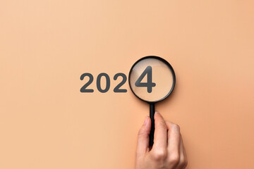 The new year 2024 is coming. Inscription 2024 with magnifying glass