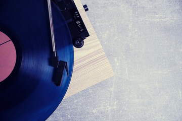 Vinyl record player with blue record installed top view gray background.
