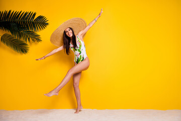 Full length photo of cute carefree girl dressed bodysuit headwear dancing empty space isolated yellow color background