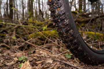 Fototapeta na wymiar Dirty electric mountain bike wheel in the forest floor