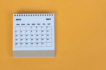 May 2024 desk calendar on yellow background. Directly above. Flat lay.