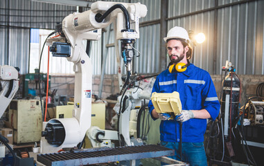 Engineers mechanic using computer controller Robotic arm for welding steel in steel factory...