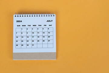 July 2024 desk calendar on yellow background. Directly above. Flat lay.