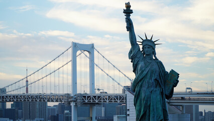 Rainbow Bridge and Statue of Liberty in Odaiba, Tokyo, Japan.