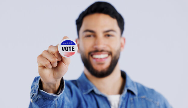 Vote, smile and portrait of man with badge in studio for choice, decision or registration on grey background. Government, politics and face of happy voter with support, freedom and party election