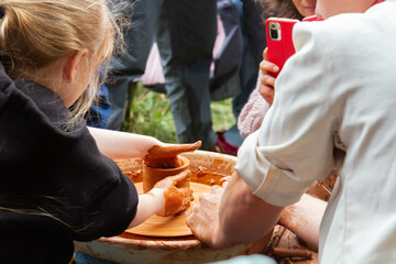 Obraz na płótnie Canvas Pottery training. Rotating a clay pot on a machine. Hands knead clay. Making a clay pot.