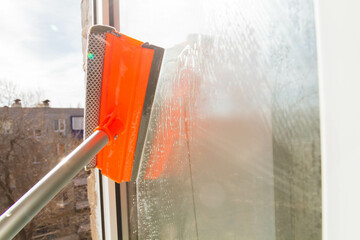 Window washing. Cleaning the window with a brush and foam. The concept of cleanliness and cleaning.