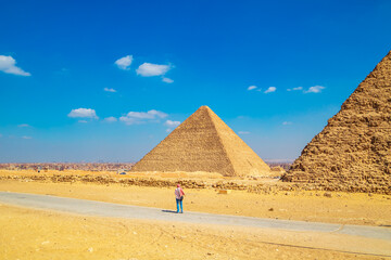 Woman tourist looking at the Great Pyramids of Egypt.