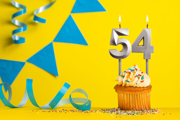 Birthday candle number 54 with cupcake - Yellow background with blue pennants