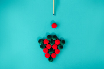 Creative Christmas tree made from red and green velvet Christmas balls and billiard cue on a...