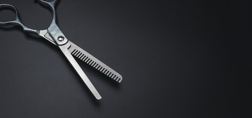 Professional Haircutting Scissors. Open hairdresser scissors on a black background. Professional tool for hairdressers scissors.