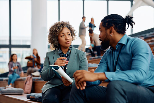 Business seminar attendees communicating on break at convention center.