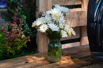 White flowers in a glass vase in the garden