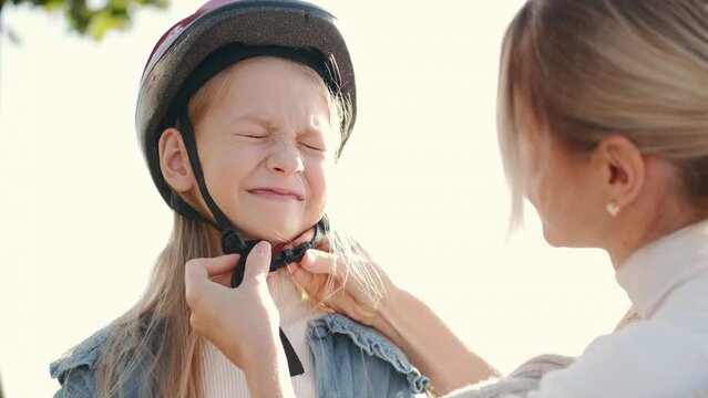 Mon helping her daughter in the park rollerblading enjoying there time togeather