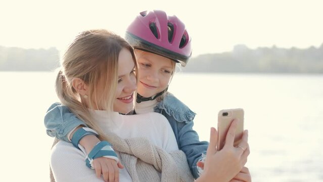 Mon helping her daughter in the park rollerblading enjoying there time togeather