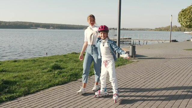 Mon helping her daughter in the park rollerblading enjoying there time togeather