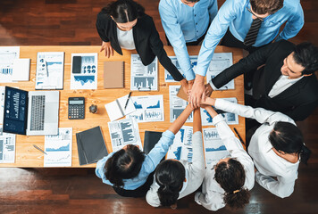 Panorama top view multiracial business people make synergy hand stack together over table with financial paper as analyst team building collaboration for corporate employee in workplace.Meticulous - Powered by Adobe