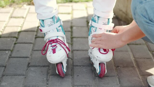 Mon helping her daughter in the park rollerblading and confirming its all set enjoying there time togeather