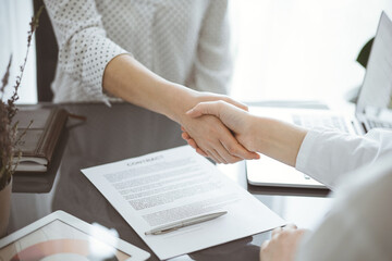 Business people signing contract papers while sitting at the glass table in office, closeup. Partners or lawyers working together at meeting. Teamwork, partnership, success concept