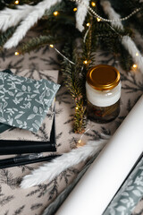 Festive decor with paper wrap, presents and a handmade candle.