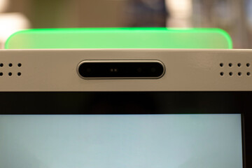 Self-service terminal. Green lamp on terminal. Camera unit at self-checkout.