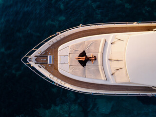 Aerial View of Woman Relaxing on Luxury Yacht Over Turquoise Sea
