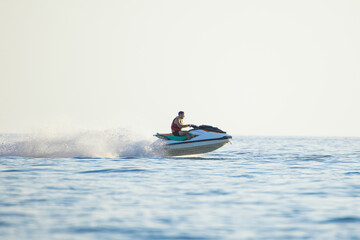 Adventurous Person Speeding on a Jet Ski Over Calm Sea Waters at Golden Hour