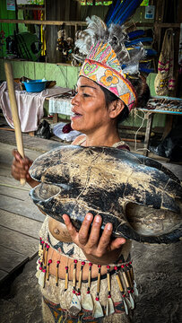 INDIGENA TIKUNA DEL AMAZONAS PERUANO TOCANDO TAMBOR CON EL CAPARAZON DE UNA TORTUGA