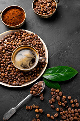 Coffee vertical background - cup of black coffee, coffee beans and ground coffee on a black background, copy space for text