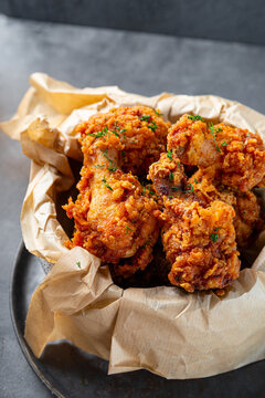 Bowl of deep fried chicken wings with bbq souse and beer on gray table close up vertical photo