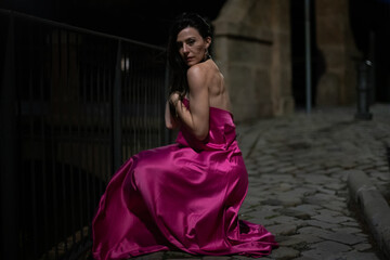 Woman in elegant dress on a castle at night