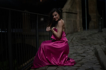 Woman in elegant dress on a castle at night