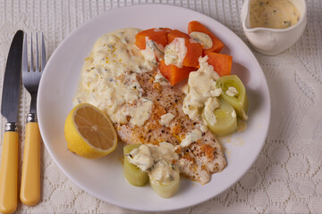 Basa fish fillet with vegetables and a white fish sauce.
