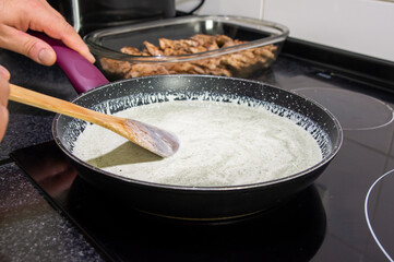 Gourmet Preparation: Chef Mixing Cream and Blue Cheese for Exquisite Meat Sauce.